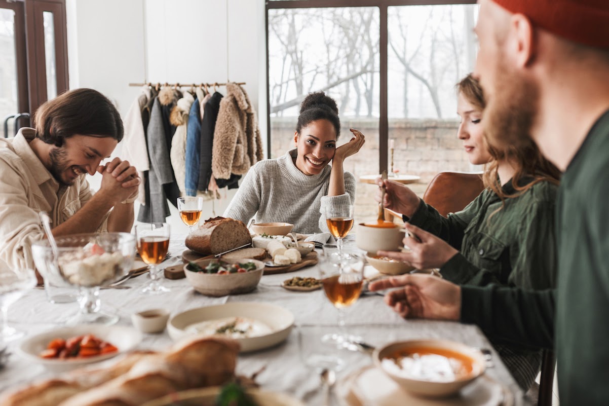 photodune-rcVRGcDK-smiling-african-american-woman-sitting-at-the-table-full-of-food-happily-talking-to-friends-photodune-main-file.jpeg